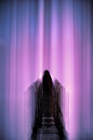 Shadowed figure of Rudolf Steiner with deep black and purple hues blending into the background.