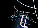 Abstract composition of colorful light streaks blending into a dark background.
