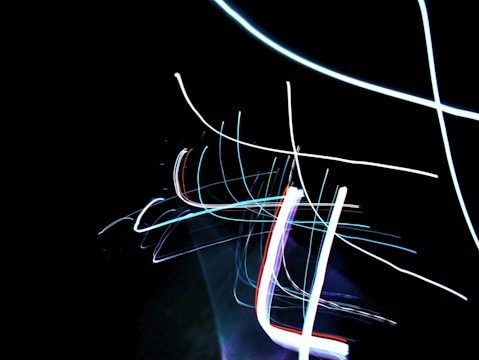 Abstract composition of colorful light streaks blending into a dark background.