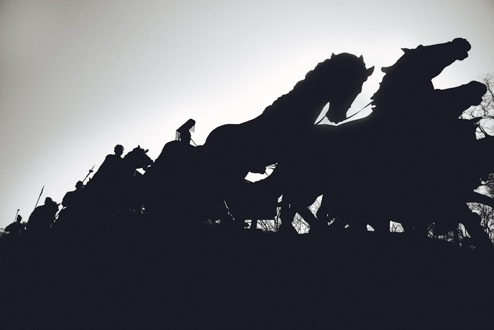 silhouette of people riding horses