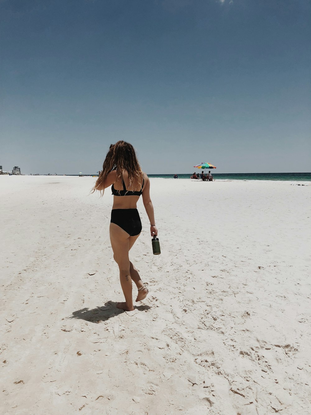 woman walking on seashore during daytime