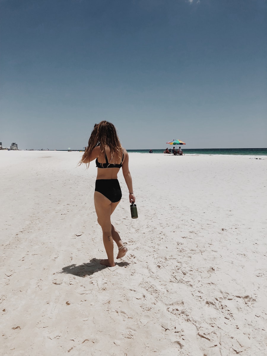 Woman walking on seashore during a bright summer day embracing the sun