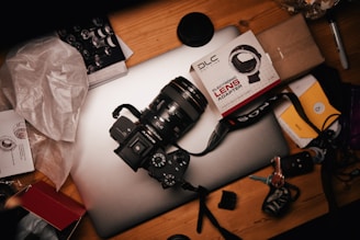 A close-up of a high-quality camera with accessories on a desk.