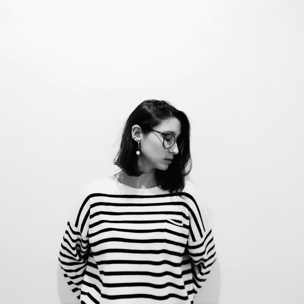 woman wearing striped shirt leaning on wall