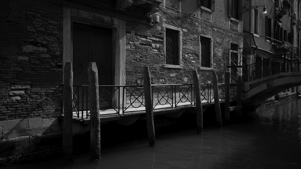 grayscale photography of building beside canal