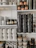 A display of several aluminium urns with matte finishes arranged neatly on shelves in a bright room.