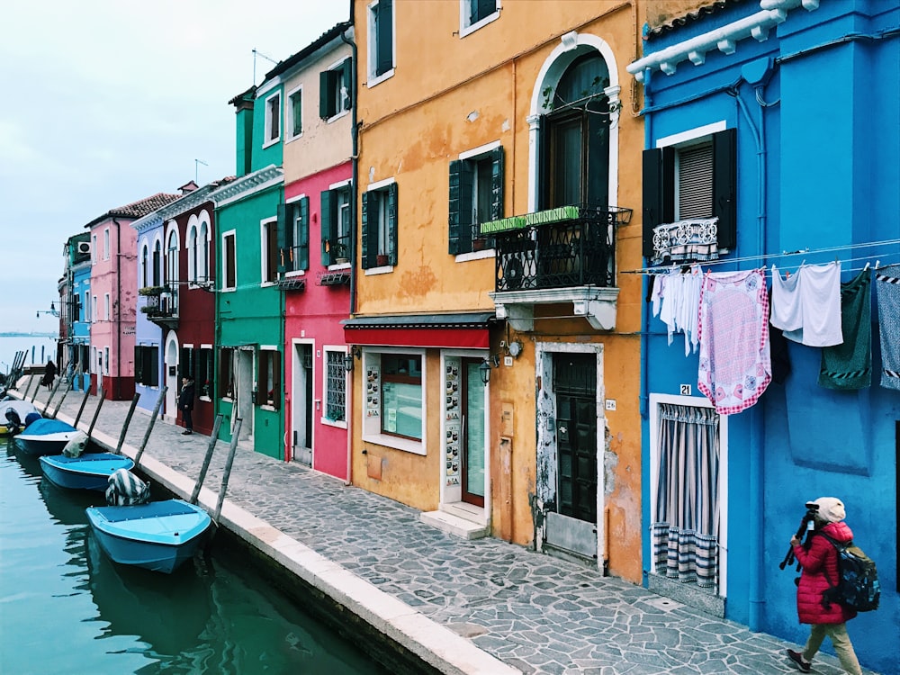 person walking near assorted-color buildings