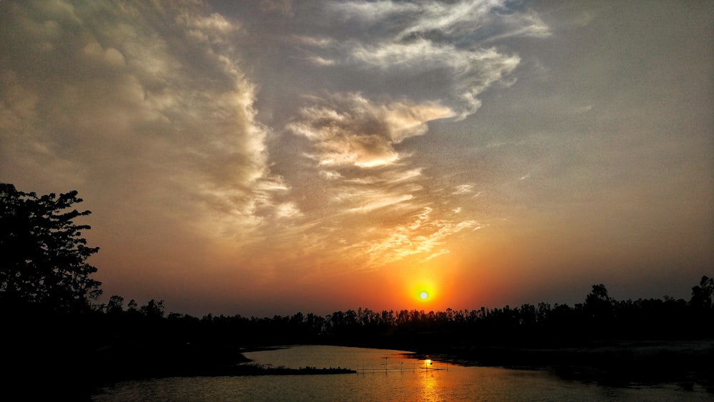 orange setting sun in horizon over river