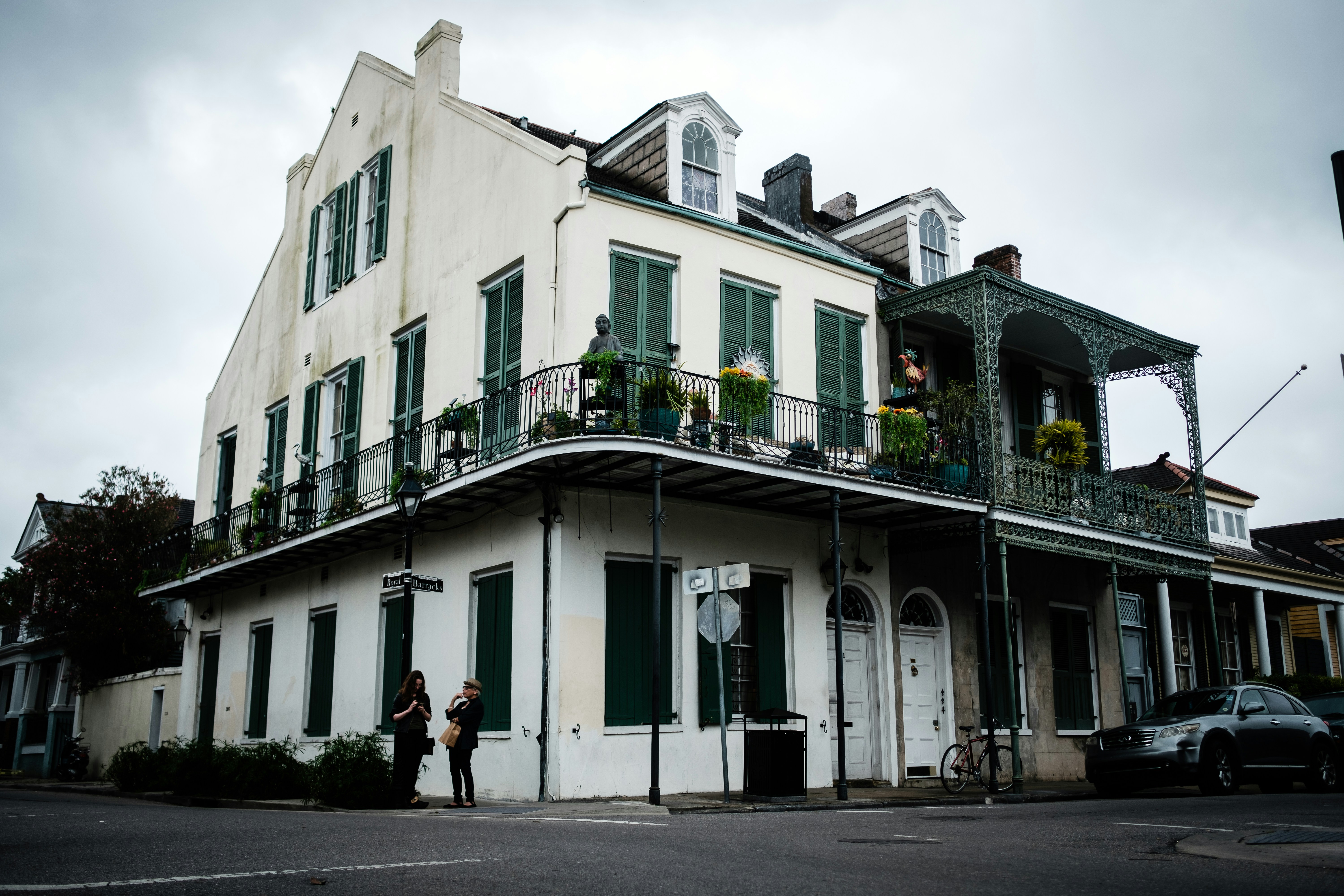 two people standing in front of house in street corner, 