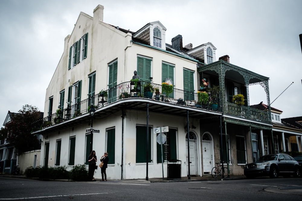 two people standing in front of house in street corner