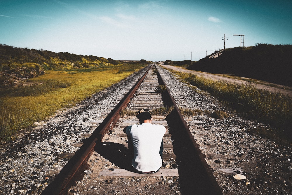 man seated on railings