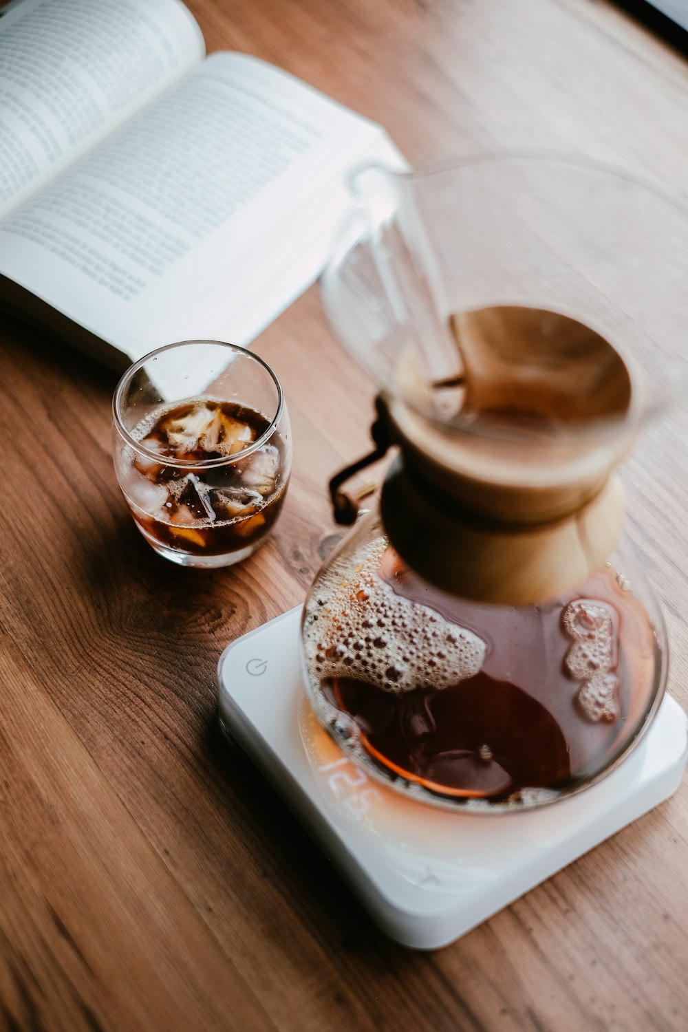 round based drinking glass beside book