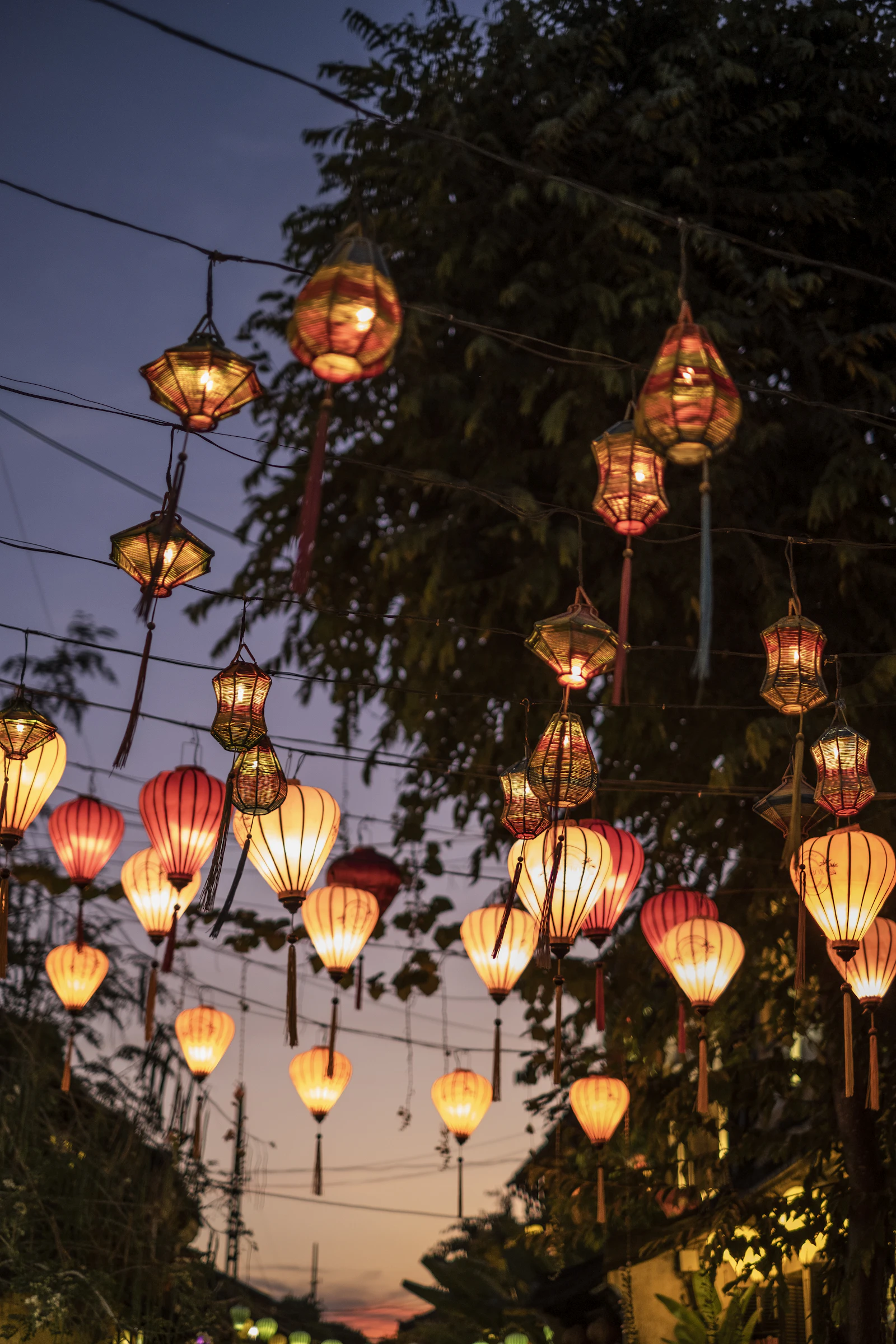 Silk lanterns glowing over a street in Hoi An's old town at dusk, a highlight for travellers using a Vietnam eSIM