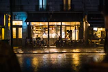 Warm amber café lights glowing through fogged windows on a rainy evening.