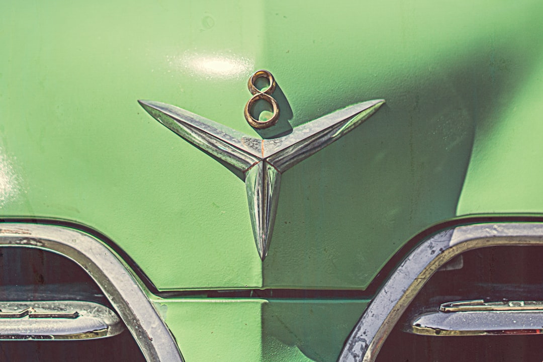 green classic car with chrome and gold 8 emblem