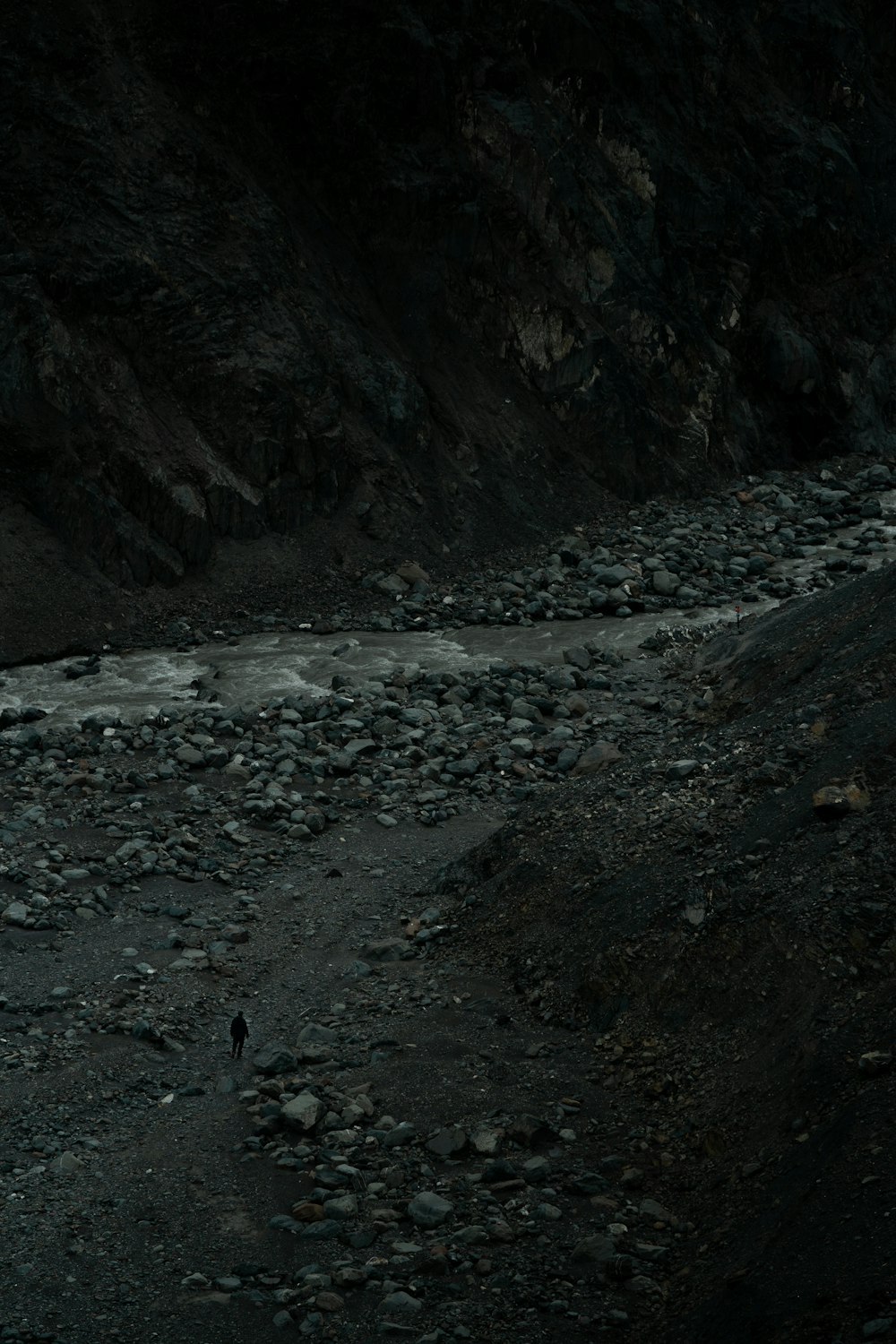 a person walking on a rocky path in the dark