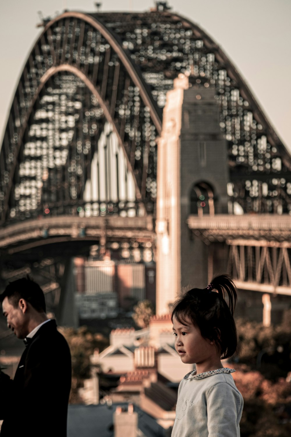 girl standing near man beside concrete bridge