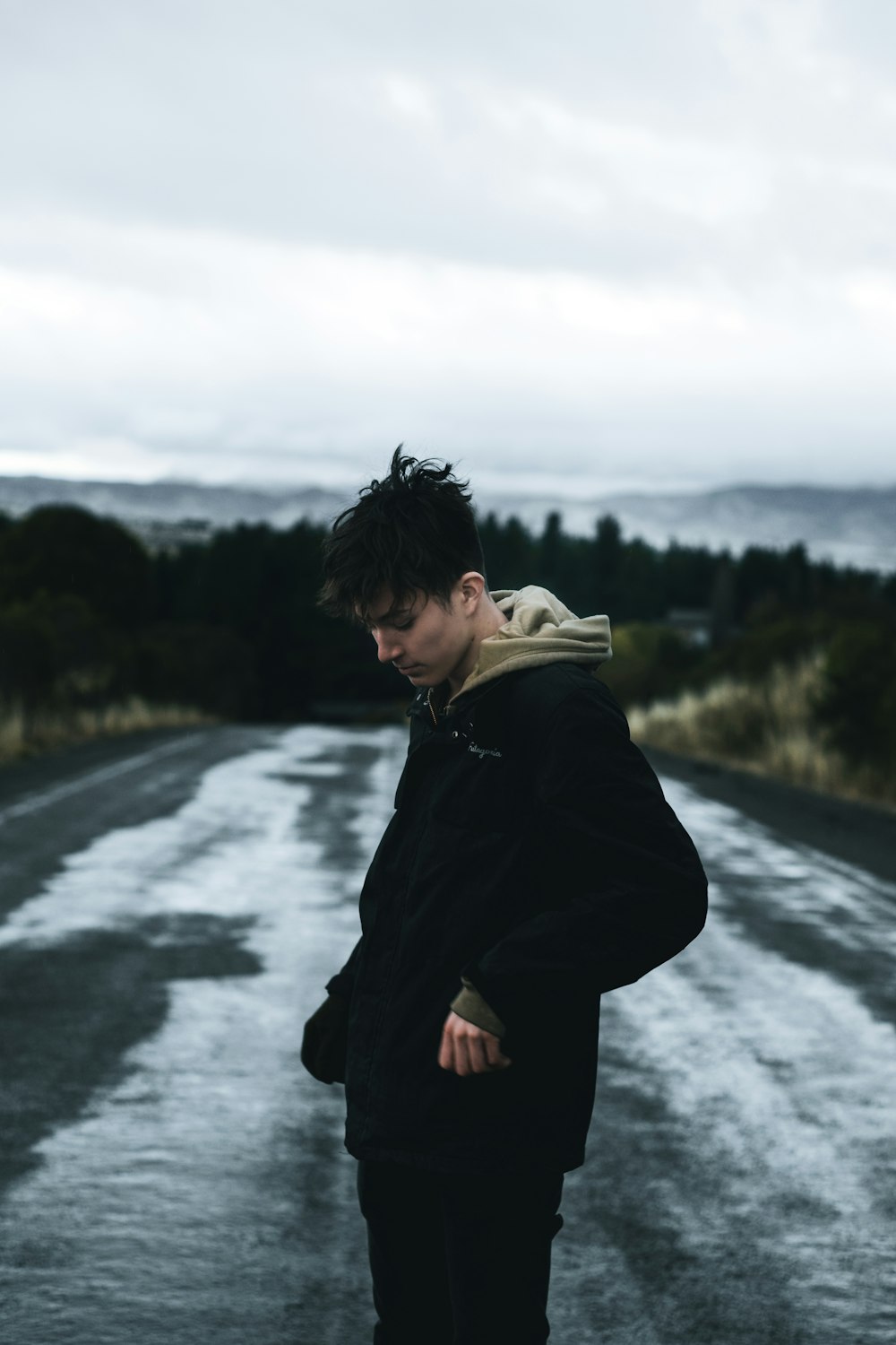 man standing alone on road looking down