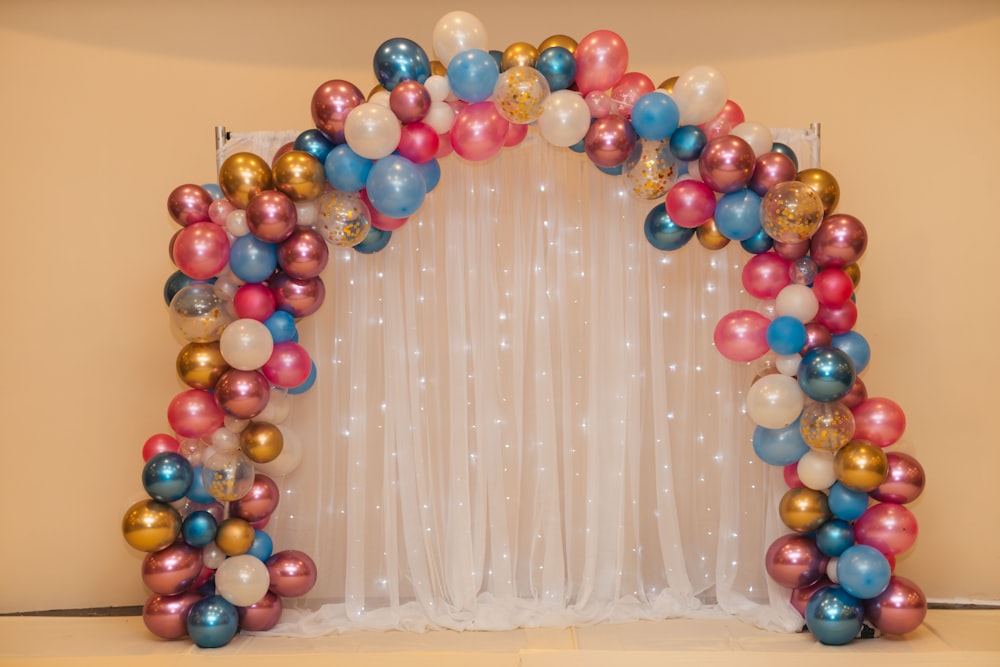 multicolored balloon arrangement near white curtain