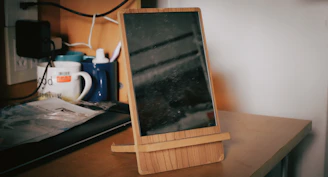 Foldable gray tablet stand on a modern office desk with a laptop and stationery.