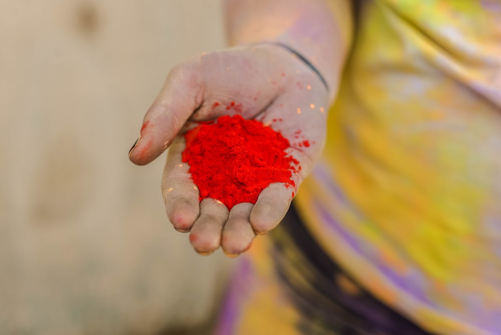 person holding red powder