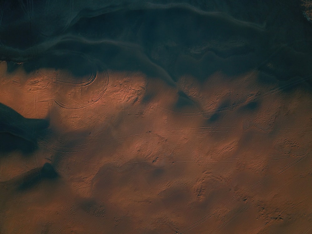 an aerial view of a desert area with sand and water