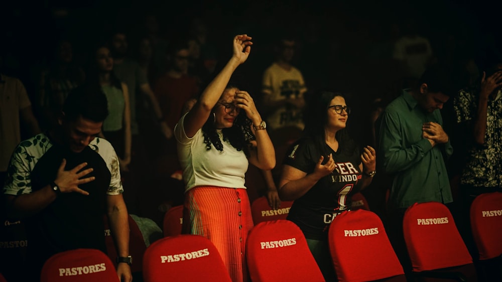 woman raising her hands while standing surrounded by people