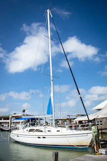 A clean, polished sailboat docked by the Naantali marina with a clear blue sky.