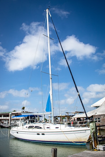 A skilled technician carefully repairing a yacht engine at the marina under a clear blue sky.