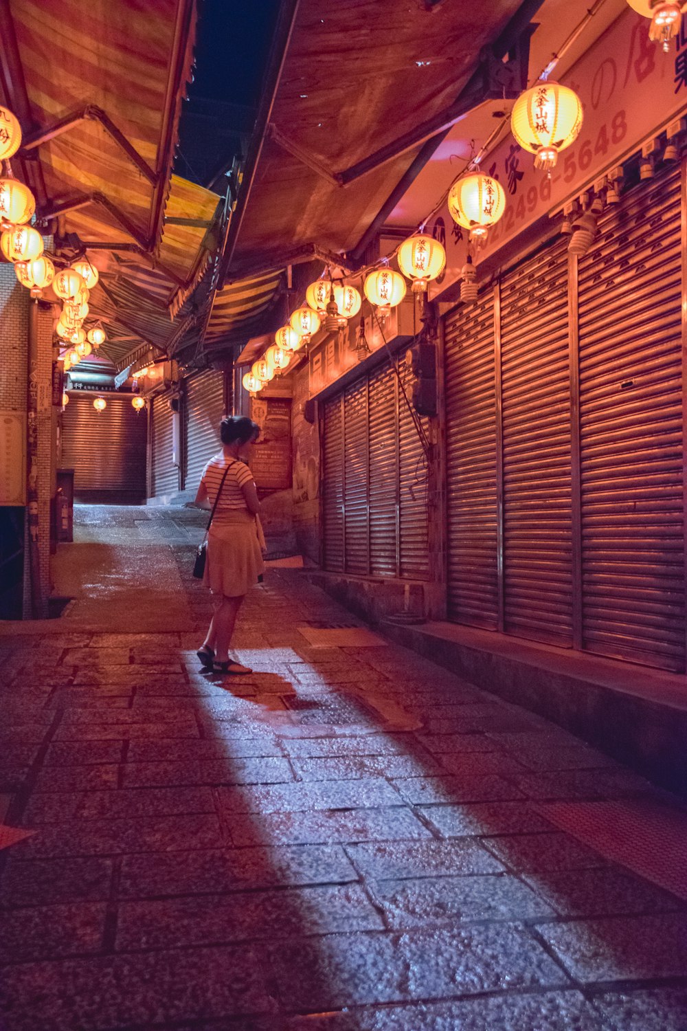 woman standing beside gray roller shutter