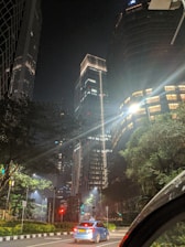 Nighttime city street in Rix with a taxi driving smoothly under streetlights.