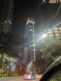 Night view of a taxi driving through illuminated urban roads.