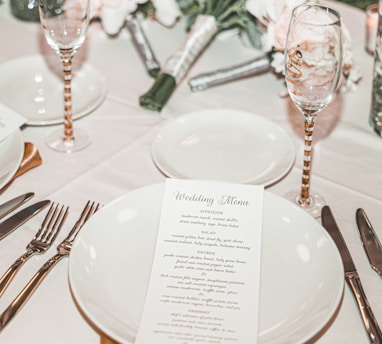 round white ceramic plate, saucer, and two clear champagne flutes