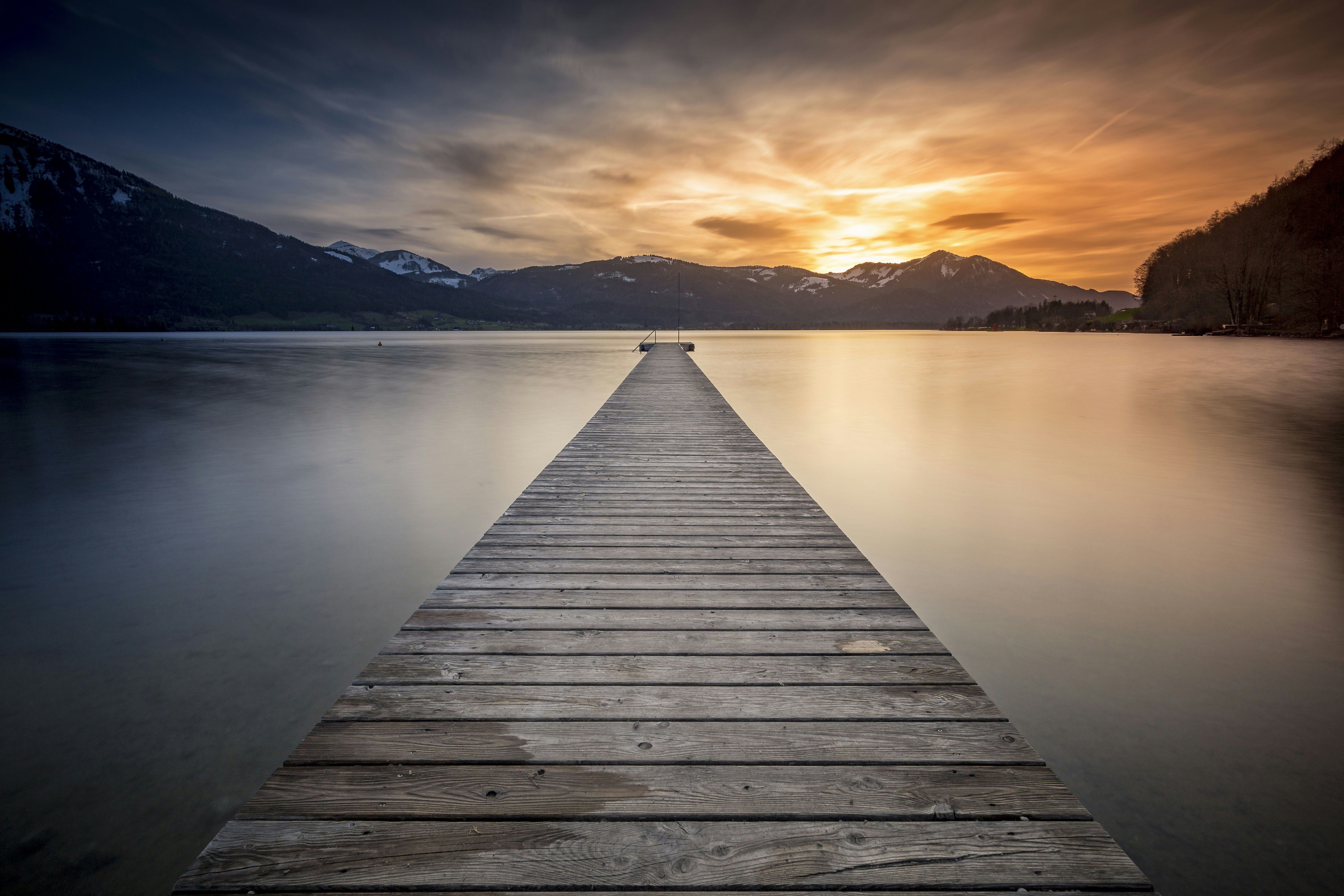 empty gray wooden boardwalk during golden hour, Evening at Lake Wolfgangsee, Austria.