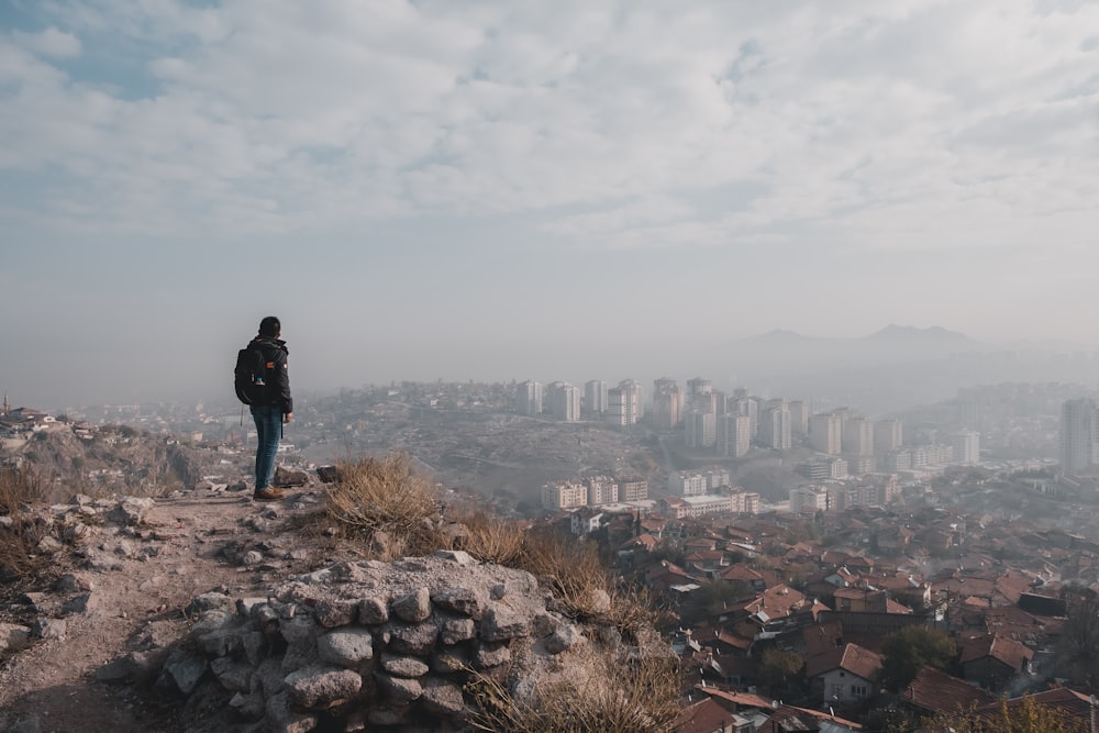 homme debout au sommet d’une colline surplombant la ville