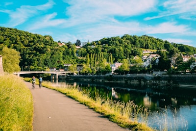 A scenic cycling route through lush green hills with a clear blue sky.