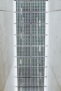 A symmetrical pattern of rectangular solar panels arranged in a grid. The panels are bordered by a light structure, and the surrounding area is a plain, smooth surface.