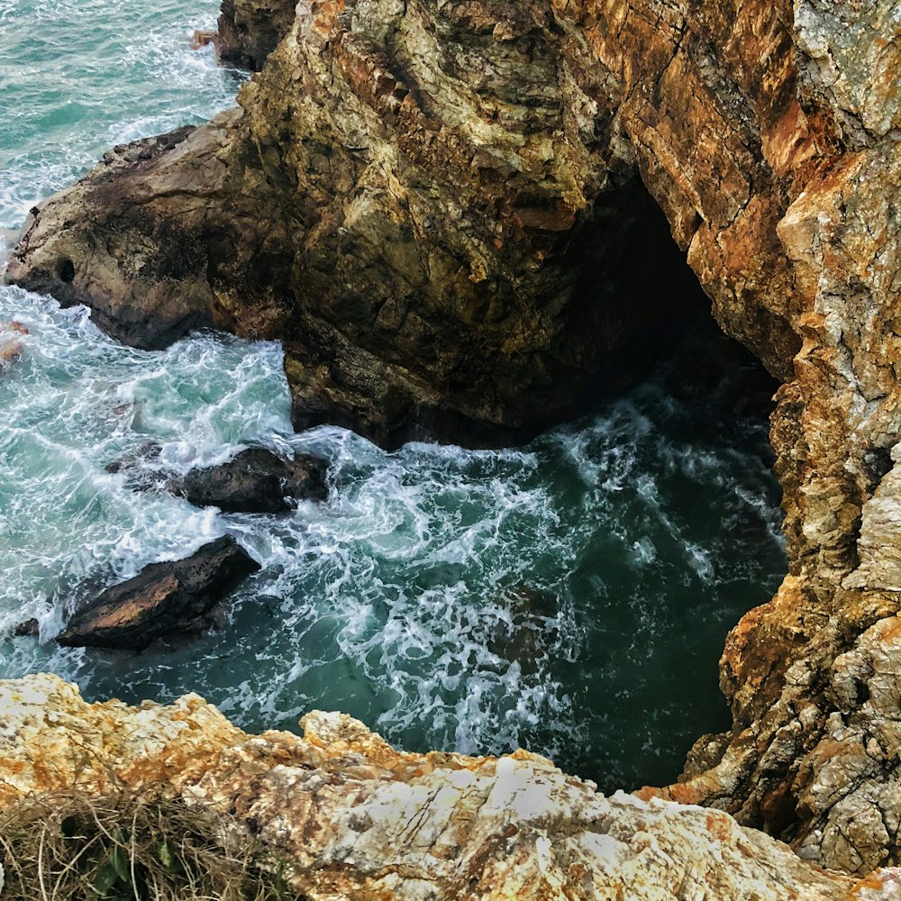 un acantilado rocoso con un cuerpo de agua que sale de él