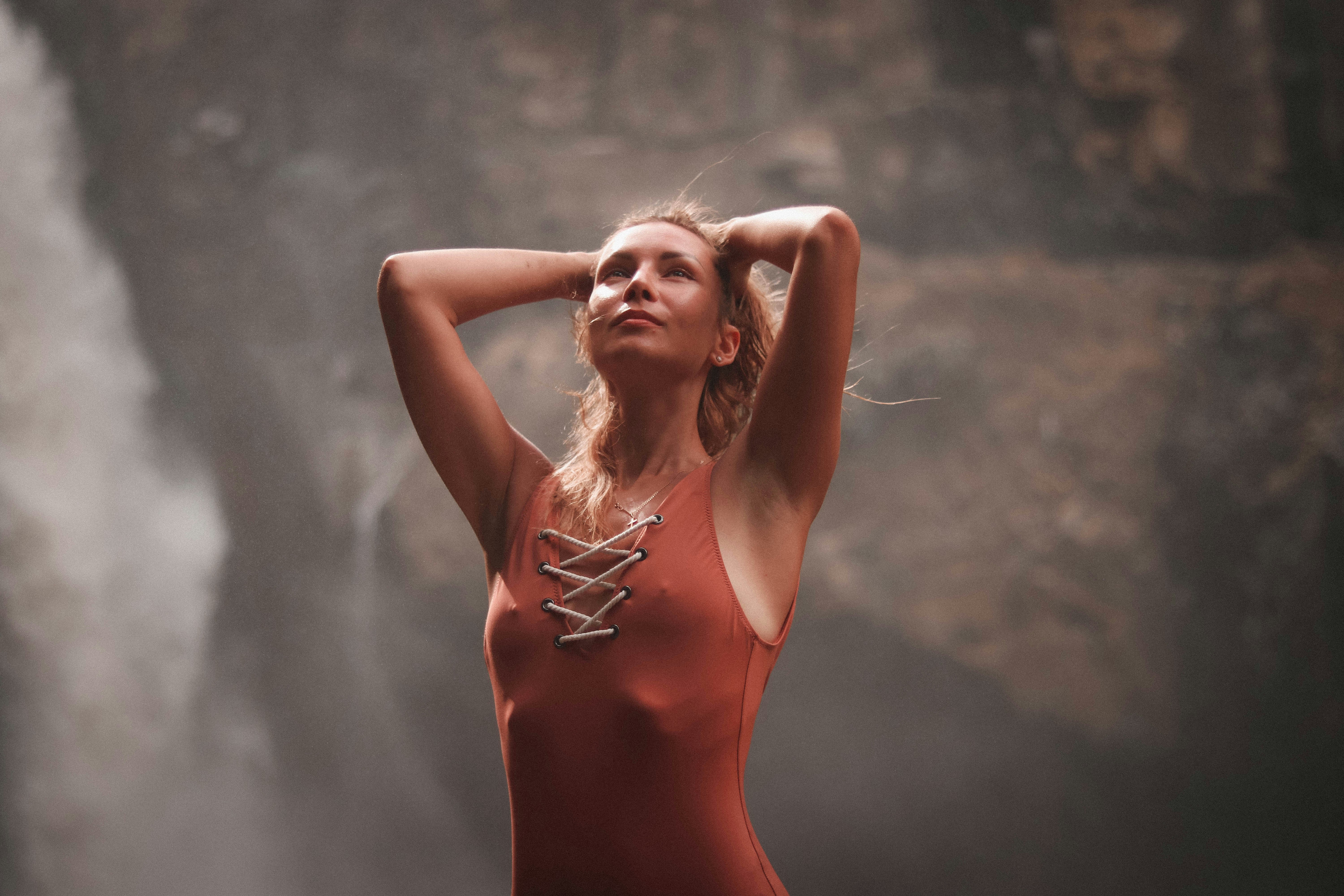 woman wearing red sleeveless dress across waterfalls