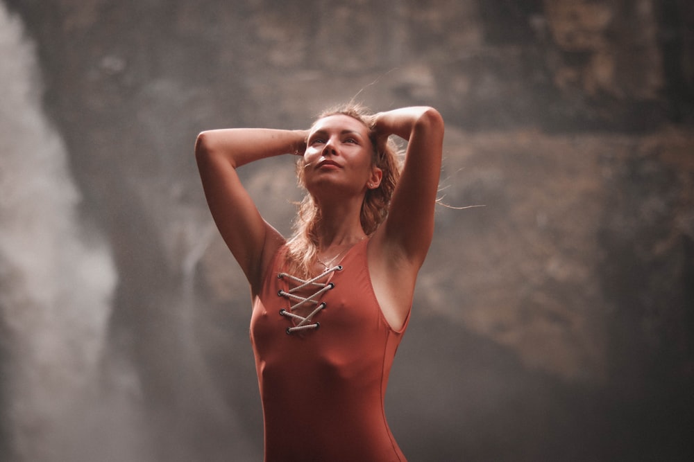 woman wearing red sleeveless dress across waterfalls