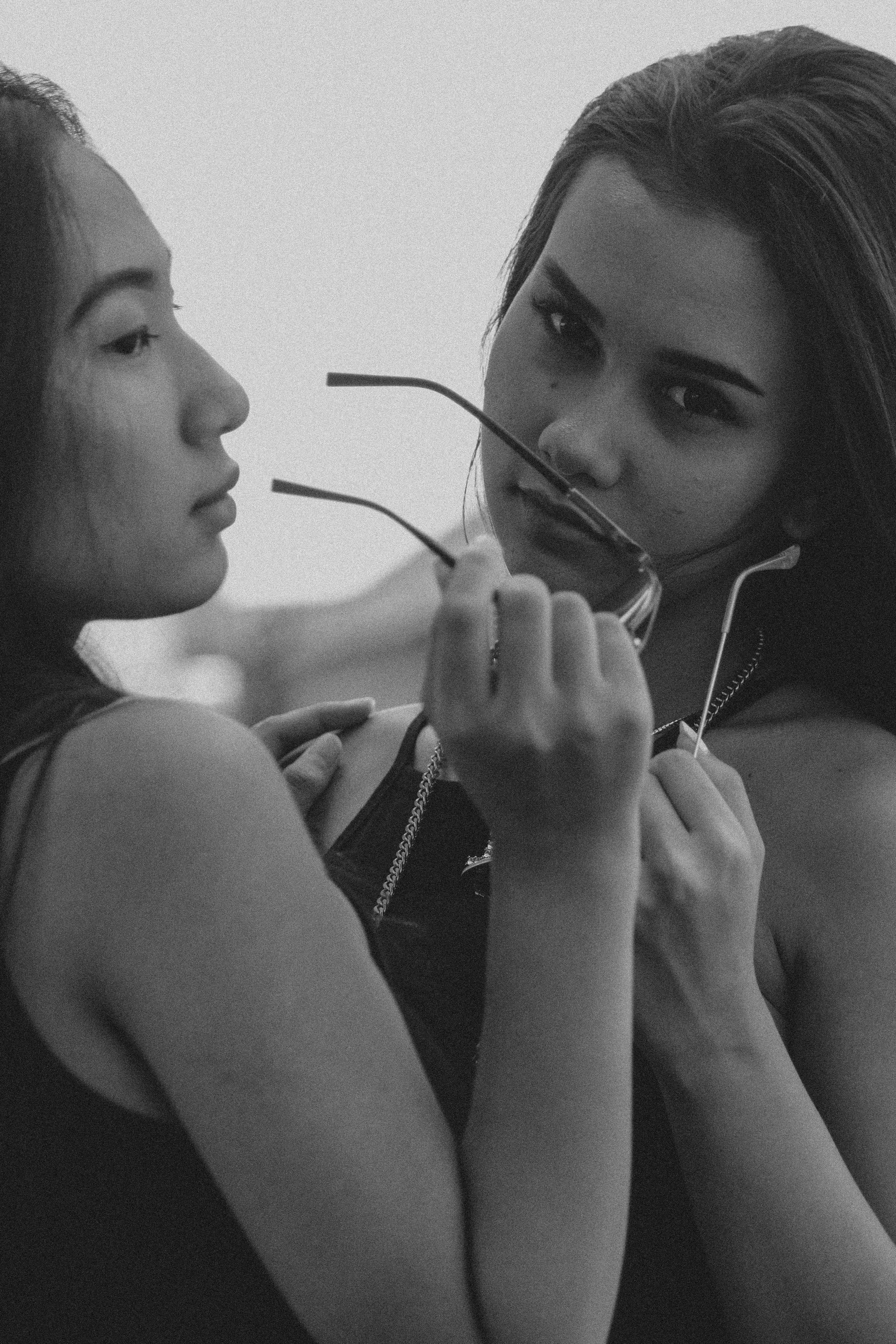close-up photo of woman holding sunglasses reflector on mirror