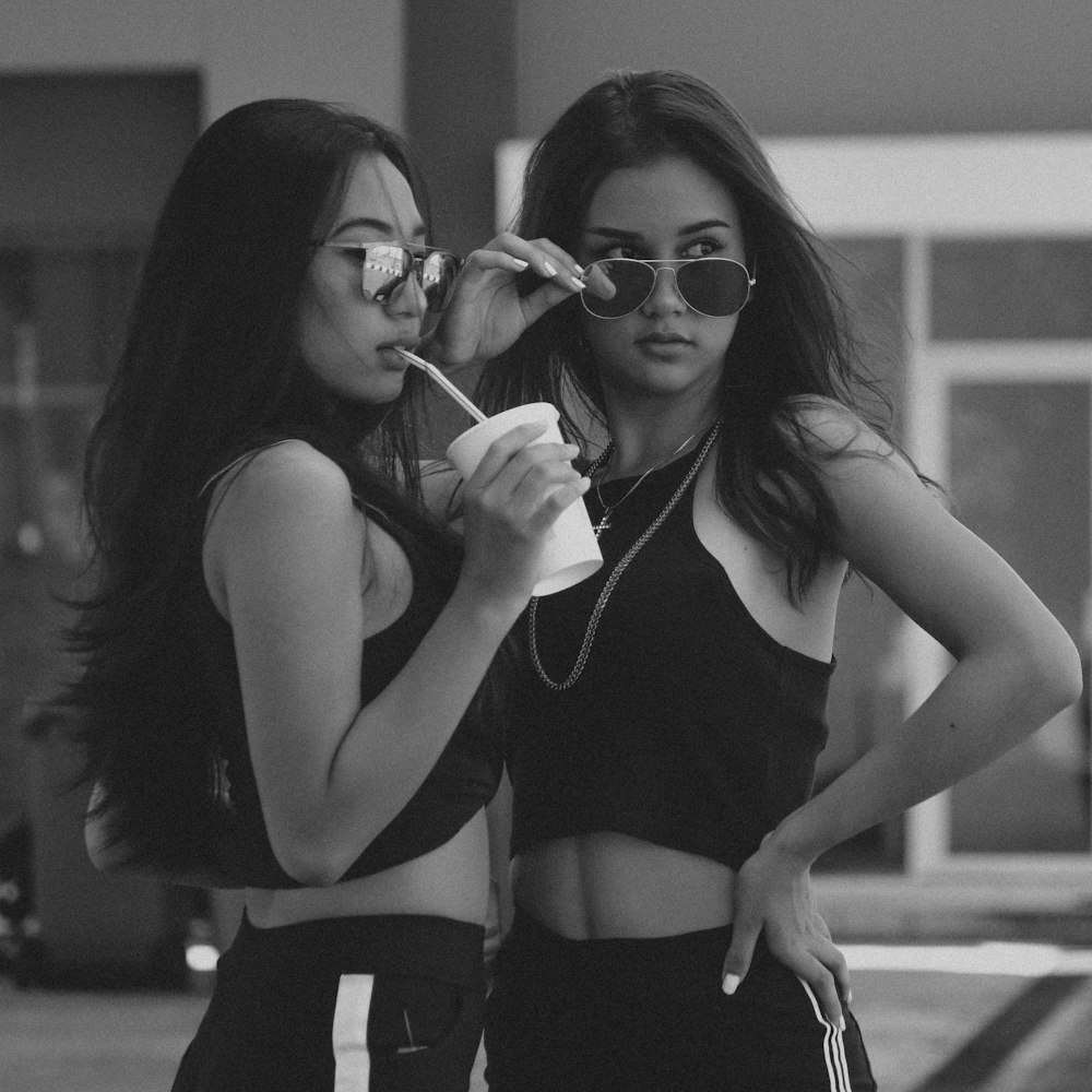 two women's wearing sunglasses in grayscale photo