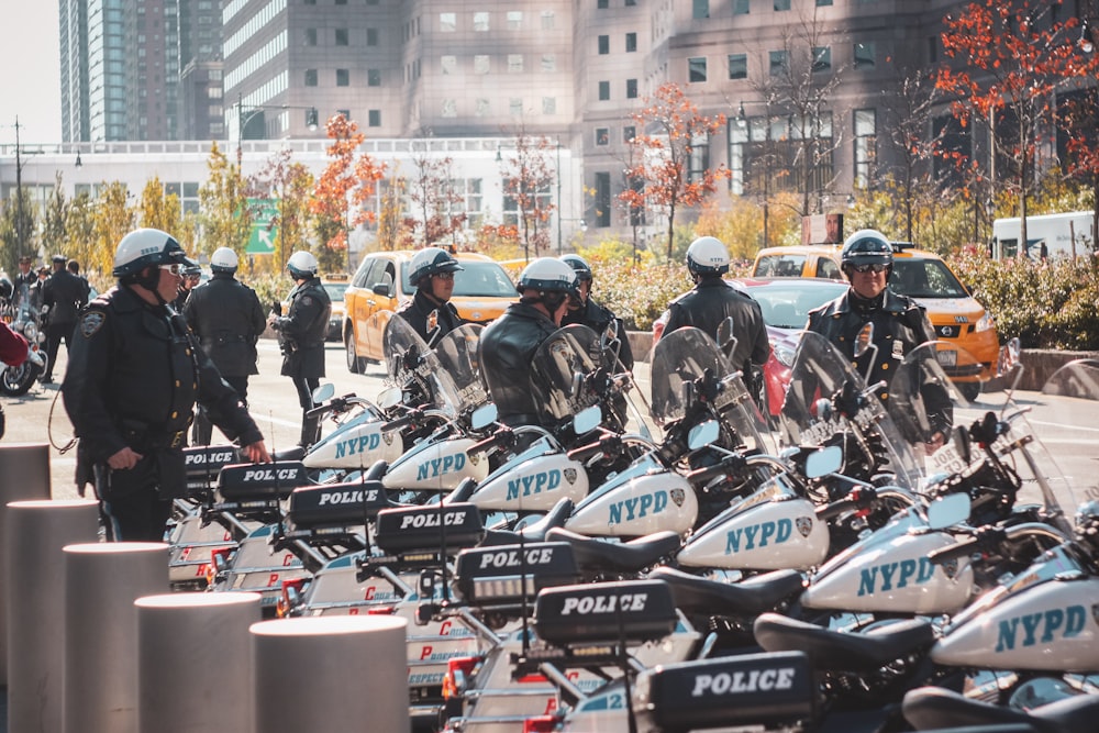 a group of police officers standing around parked motorcycles