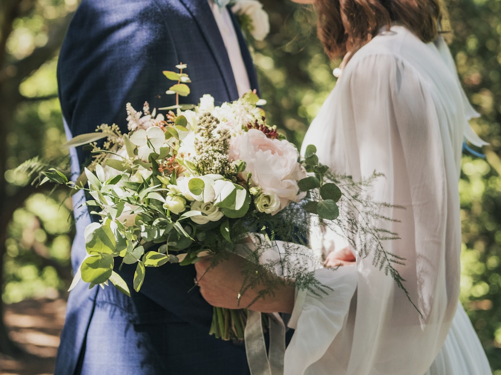 married couple standing under green tree