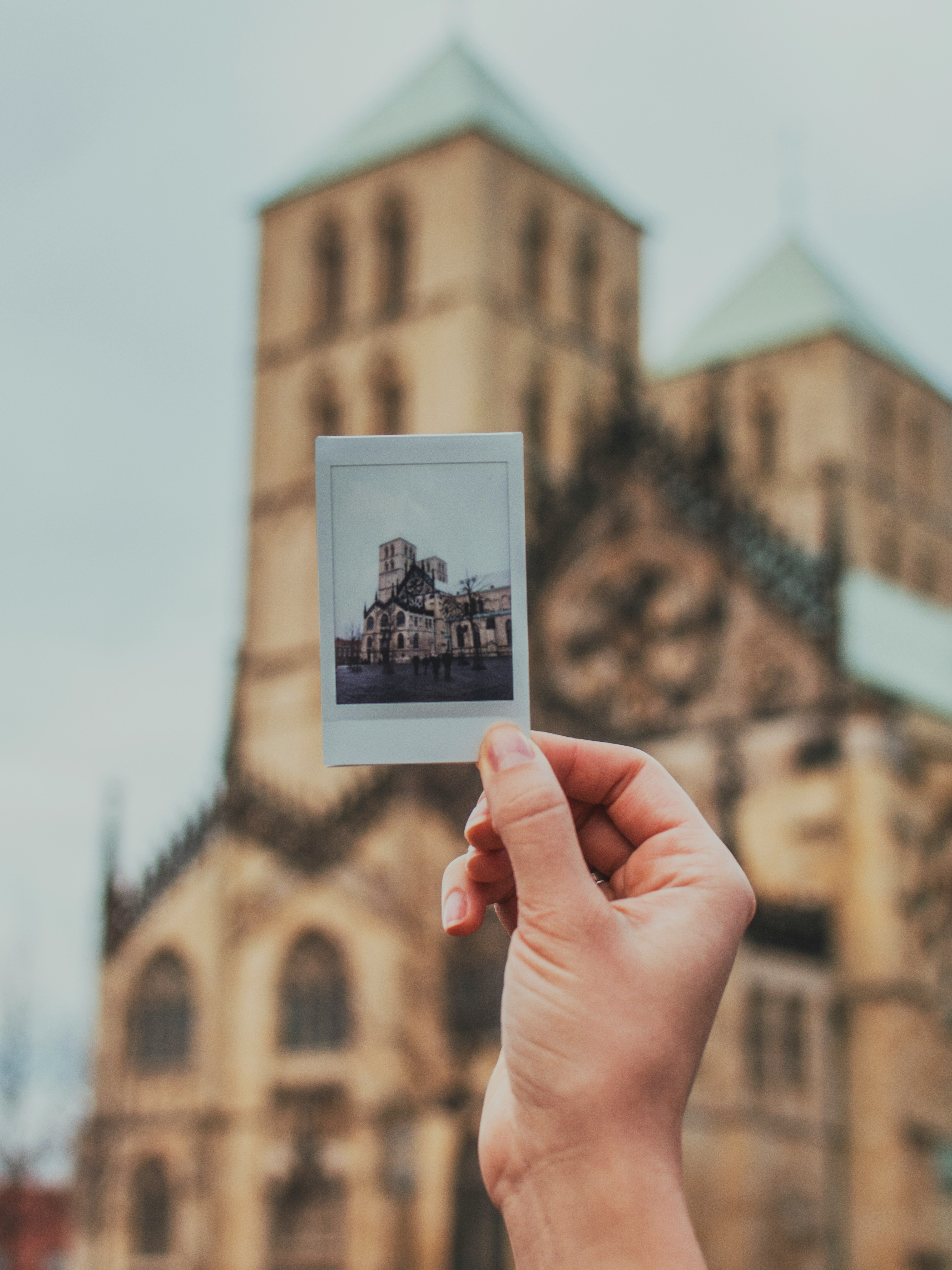 person holding brown concrete building photo