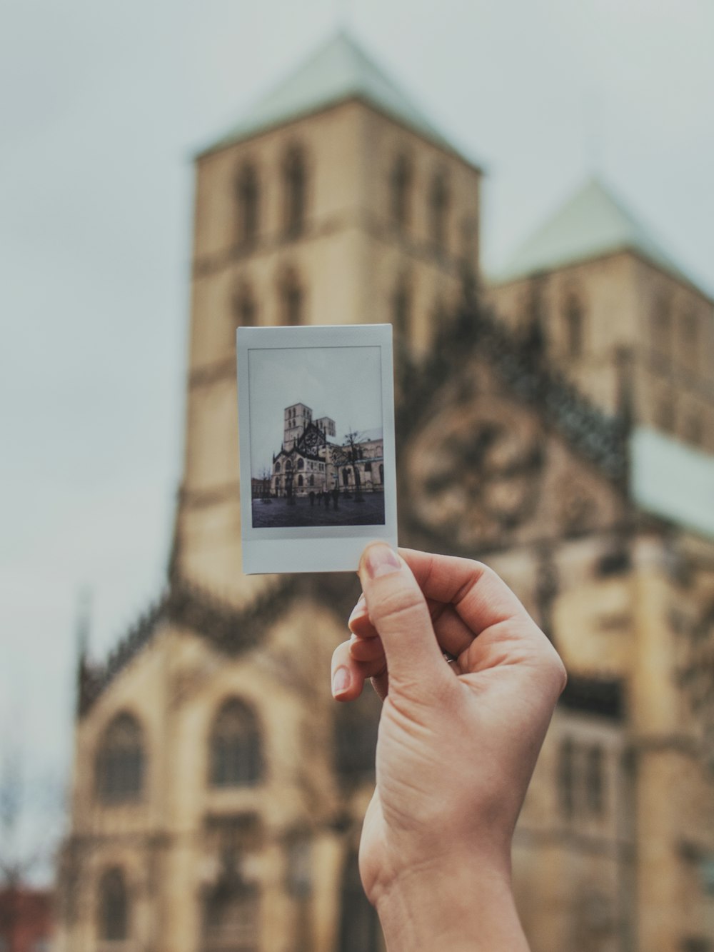 person holding brown concrete building photo