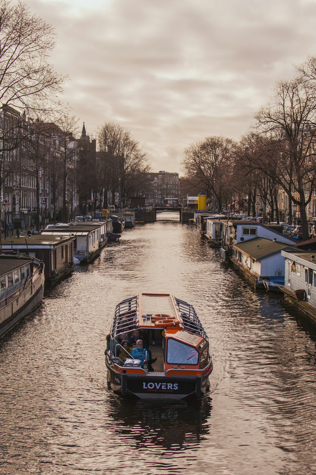 Amsterdam canal with boats during golden hour