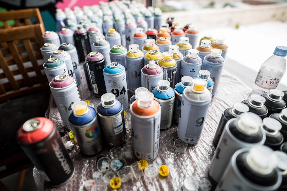 assorted-color spray bottle lot on grey surface