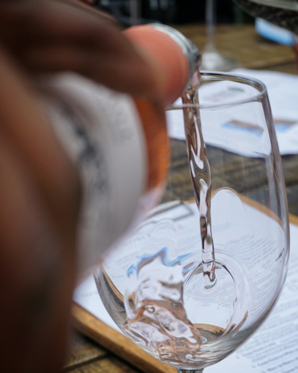 person pouring white wine in glass