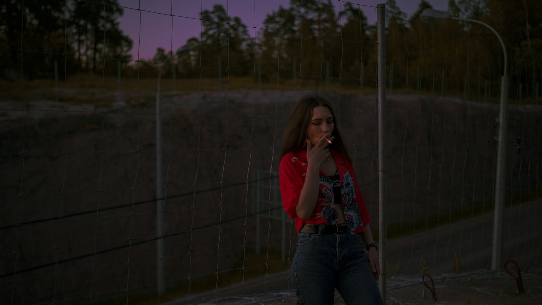 woman in red shirt smoking cigarette